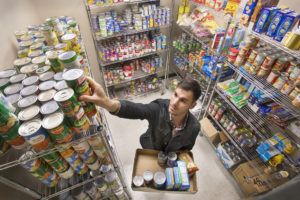 Photo caption: Graduate student Trey Delcambre organizes canned food donated to UL Lafayette’s Campus Cupboard. The on-campus pantry opens Tuesday in the University’s Intensive English Program building, 413 Brook Ave. (Photo credit: Doug Dugas / University of Louisiana at Lafayette).